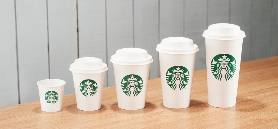 A line of Starbucks cups from small espresso size, to large Venti size