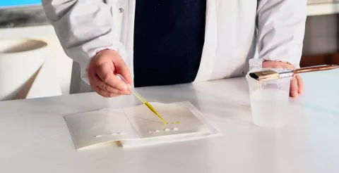 Man testing leak-proof carboard material in a lab