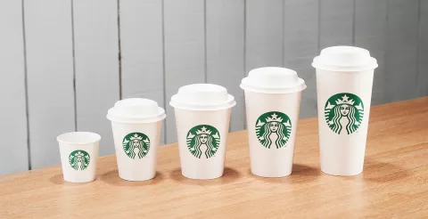 A line of Starbucks cups from small espresso size, to large Venti size